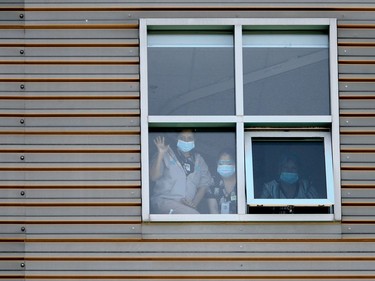 People look out a window at Deer Lodge Centre at a small convoy of police and military vehicles.  The gesture was organized to commemorate the 75th anniversary of Victory in Europe (VE) Day. Friday, May 8, 2020.