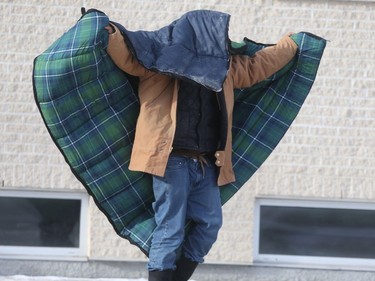 A person adjusts the sleeping bag they are using to keep warm while outside, in Winnipeg.  Saturday, Dec. 19, 2020.