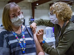 Jennifer Cochrane, a Public Health Nurse with Prairie Mountain Health in Virden, administers the COVID-19 vaccine to Joanna Robb, the first person in line during the first day of immunizations at the Brandon COVID-19 vaccination supersite at the Keystone Centre on Monday. (Courtesy the Government of Manitoba)