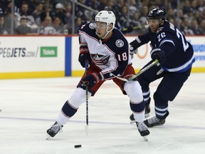 Columbus Blue Jackets centre Pierre-Luc Dubois (left) skates away from Winnipeg Jets forward Blake Wheeler in Winnipeg on Thursday, Jan. 30, 2019. Dubois's 14-day quarantine since arriving from Columbus will be over on Saturday.