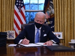 U.S. President Joe Biden sits in the Oval Office as he signs a series of orders at the White House in Washington, D.C., after being sworn in at the U.S. Capitol on Jan. 20, 2021.