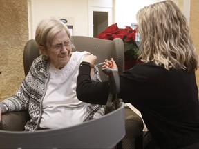 Paramedic Jessi Bittner inoculates Margaret Watson, 94, a resident at Oakview Place Long Term Care Residence, with her COVID-19 vaccine in the Winnipeg care home, Monday, January 11, 2021. Watson was the first member of the public to receive the vaccine in Winnipeg. THE CANADIAN PRESS/John Woods