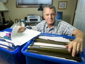 In this June 13, 2016 file photo, Dennis Young sits with his High River-related files inside his home in Airdrie, Alta.