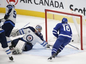 Leafs winger Mitch Marner taps in a shot past Winnipeg Jets goalie Connor Hellebuyck last night. Jack Boland/Postmedia network