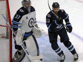 Trevor Lewis (right) takes up position in front of goaltender Connor Hellebuyck during a scrimmage at Winnipeg Jets training camp at Bell MTS Iceplex in Winnipeg on, Jan. 6, 2021.