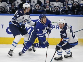 Winnipeg Jets Logan Stanley D (64) lays a check on Toronto Maple Leafs Zach Hyman C (11) during the first period in Toronto on Monday January 18, 2021. Jack Boland/Toronto Sun/Postmedia Network