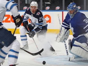Paul Stastny #26 of the Winnipeg Jets feeds the puck in front of goalie Frederik Andersen #31 of the Toronto Maple Leafs during an NHL game at Scotiabank Arena on January 18. 2021 in Toronto, Ontario, Canada.