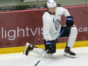 Patrik Laine stretches during Winnipeg Jets training camp at Bell MTS Iceplex in Winnipeg on Mon., Jan. 4, 2021. Laine won't play on Tuesday, missing his second straight game due to injury. Kevin King/Winnipeg Sun/Postmedia Network