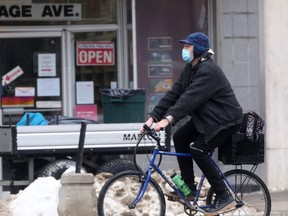 A person rides their bike along Portage Avenue, in Winnipeg on Friday.