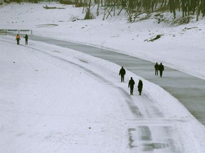 People enjoy mild weather by walking and skating along the Assiniboine River, in Winnipeg on Friday, Jan. 8.