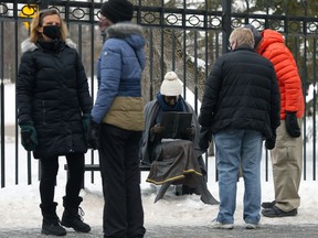 People congregate near The Lady in the Park statue at Assiniboine Park in Winnipeg on Sunday.