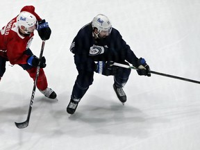 Dylan DeMelo (left) defends against Nate Thompson during Winnipeg Jets training camp at Bell MTS Iceplex in Winnipeg on Sunday, Jan. 10, 2021.