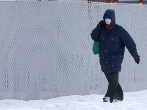A person wears a mask while walking in Winnipeg on Friday.