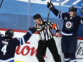 Winnipeg Jets forward Patrik Laine (right) celebrates his overtime goal against the Calgary Flames during NHL action in Winnipeg with Neal Pionk on Thursday, Jan. 14, 2021.