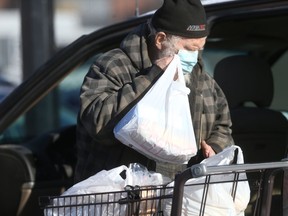 A person wears a mask while collecting groceries, in Winnipeg on Tuesday, Jan. 19, 2021.