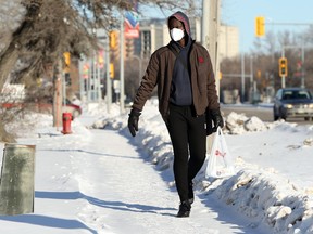 A man wearing a mask walks along Pembina Highway in Winnipeg on Tuesday, Jan. 19, 2021.