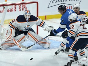 Winnipeg Jets forward Andrew Copp (centre) looks to deflect a shot on Edmonton Oilers goaltender Mikko Koskinen in Winnipeg on Sunday