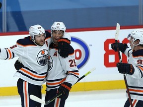 Edmonton Oilers C Leon Draisaitl (left) celebrates his game-winning goal over the Winnipeg Jets in Winnipeg with D Darnell Nurse (centre) and Ryan Nugent-Hopkins on Sunday, Jan. 24, 2021.