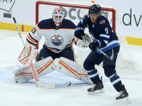 Winnipeg Jets forward Andrew Copp (right) attempts to tip a shot past Edmonton Oilers goaltender Mikko Koskinen in Winnipeg on Tuesday, Jan. 26, 2021.