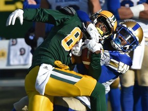 After making the catch Edmonton Eskimos Bryant Mitchell (80) gets hauled down by the neck by Winnipeg Blue Bombers Chris Humes (35) during CFL action in the last game of the season at Commonwealth Stadium in Edmonton, November 3, 2018. Ed Kaiser/Postmedia