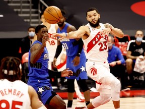 Raptors' Fred VanVleet (right) passes the ball to teammate DeAndre' Bembry as Orlando Magic's Dwayne Bacon defends during the first quarter at Amalie Arena in Tampa on Sunday, Jan. 31, 2021.