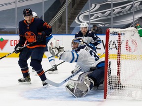 Jets goaltender Connor Hellebuyck makes a save on Alex Chiasson  of the Edmonton Oilers during Winnipeg's 3-2 loss at Rogers Place on Wednesday night.