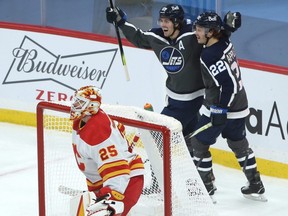 Winnipeg Jets centre Mark Scheifele (top left) celebrates his goal against the Calgary Flames in Winnipeg on Thurs., Feb. 4, 2021 with Mason Appleton.