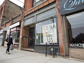 A closed storefront boutique business called Francis Watson pleads for help displaying a sign in Toronto on Thursday, April 16, 2020.