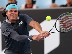 Milos Raonic hits a return against Marton Fucsovics during their match at the Australian Open in Melbourne on February 12, 2021.
