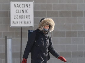 A person walks past a sign for a vaccination centre, in downtown Winnipeg on Saturday.