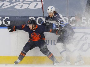 Winnipeg Jets defencemen Nate Beaulieu (88) and Edmonton Oilers forward Josh Archibald (15) battles along the boards for a loose puck during the first period at Rogers Place in Edmonton on Monday.