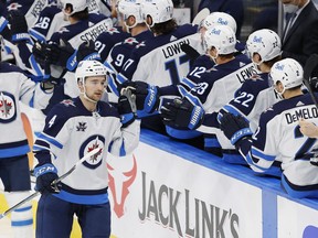 Feb 17, 2021; Edmonton, Alberta, CAN; Winnipeg Jets defensemen Neal Pionk (4) celebrates a third period goal against the Edmonton Oilers with teammates at Rogers Place. Mandatory Credit: Perry Nelson-USA TODAY Sports