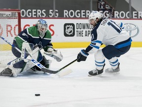 Vancouver Canucks goalie Thatcher Demko (35) makes a save on Winnipeg Jets forward Nate Thompson (11) in the second period at Rogers Arena in Vancouver on Friday.