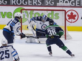 Winnipeg Jets defenceman Nathan Beaulieu (88) looks on as goalie Connor Hellebuyck (37) makes a save on Vancouver Canucks forward Nils Hoglander (36) in the first period at Rogers Arena in Vancouver.