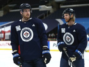 Pierre-Luc Dubois (left) chats with Kyle Connor during his first practice with the Winnipeg Jets on Sunday.