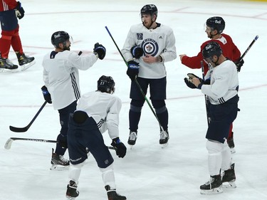 Pierre-Luc Dubois (centre) talks things over with the second power-play unit during his first Winnipeg Jets practice on Sunday, Feb. 7, 2021. From left are Mathieu Perreault, Nikolaj Ehlers, Andrew Copp, and Neal Pionk (red jersey).