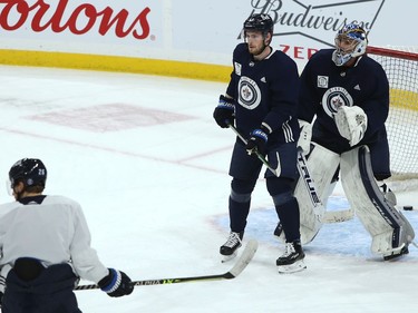 Pierre-Luc Dubois sets up a screen on goaltender Connor Hellebuyck during Winnipeg Jets practice on Sunday, Feb. 7, 2021.