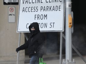 A person passes a sign for vaccine clinic in downtown Winnipeg on Tuesday, Feb. 9, 2021. Chris Procaylo/Winnipeg Sun