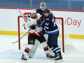 Winnipeg Jets defenceman Josh Morrissey (right) battles with Ottawa Senators centre Colin White in front of goaltender Connor Hellebuyck in Winnipeg on Thurs., Feb. 11, 2021. Kevin King/Winnipeg Sun/Postmedia Network