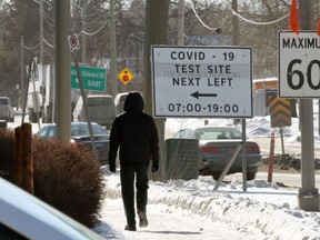 A pedestrian nears a COVID-19 testing site sign on King Edward Street in Winnipeg on Tues., Feb. 16, 2021. Kevin King/Winnipeg Sun/Postmedia Network