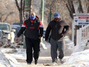 Two men with face coverings walk in the Osborne Village area of Winnipeg on Monday, Feb. 22, 2021.