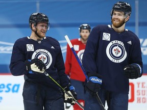 Andrew Copp (left) laughs with Adam Lowry during Winnipeg Jets practice at Bell MTS Place in Winnipeg on Tues., Feb. 23, 2021. Kevin King/Winnipeg Sun/Postmedia Network