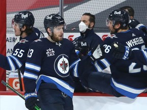 Winnipeg Jets forward Pierre-Luc Dubois (13) is congratulated at the bench after his goal against the Montreal Canadiens in Winnipeg on Thursday, Feb. 25, 2021.