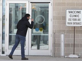 A man checks to see if he has the right doors near the COVID-19 vaccination super-site at the Winnipeg Convention Centre in Winnipeg on Sunday, Feb. 28, 2021.