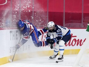 Winnipeg Jets forward Mathieu Perreault avoids the check from Montreal Canadiens defenceman Alexander Romanov  during Thursday's game.