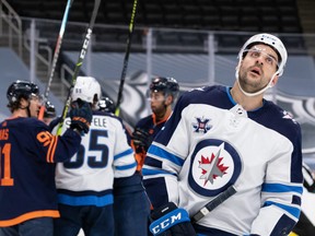 Winnipeg Jets’ Dylan DeMelo (2) reacts after being stopped by Edmonton Oilers’ goaltender Mike Smith (41) during second period NHL action at Rogers Place in Edmonton, on Saturday.