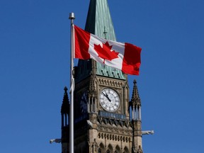 A Canadian flag flies in front of the Peace Tower on Parliament Hill in Ottawa.