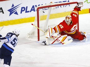 Calgary Flames goalie Jacob Markstrom is scored on by Winnipeg Jets Mark Scheifele in first period NHL action at the Scotiabank Saddledome in Calgary on Monday, March 29, 2021.