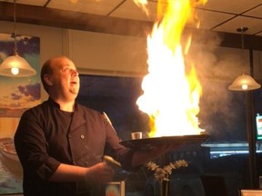 Nick at Helios (pre-pandemic) preparing a fiery fried cheese Greek dish called Saganaki.