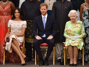 In this file photo taken on June 26, 2018, Meghan, Duchess of Sussex, Britain's Prince Harry, Duke of Sussex and Britain's Queen Elizabeth II pose for a picture during the Queen's Young Leaders Awards Ceremony at Buckingham Palace in London.